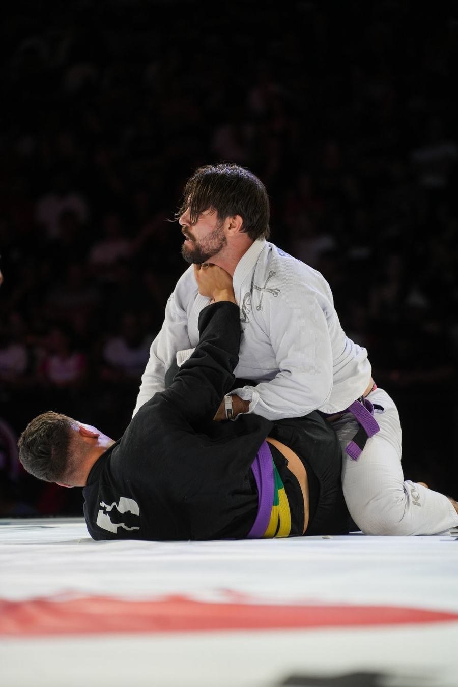 Atleta de quimono branco controlando o adversário no tatame do CWB Black Belt