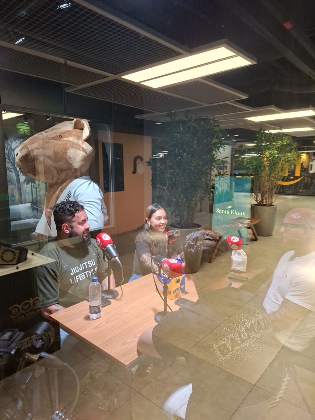 Gravação do podcast vista através do vidro, com a capivara ao fundo