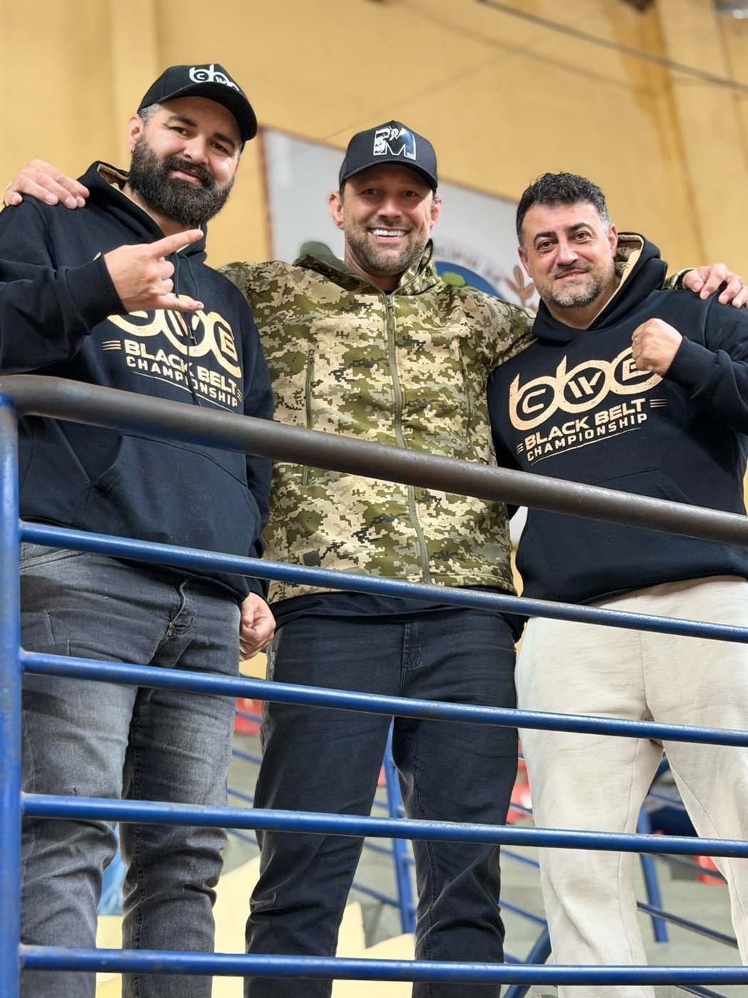 Organizadores com moletons do CWB Black Belt na arquibancada do ginásio